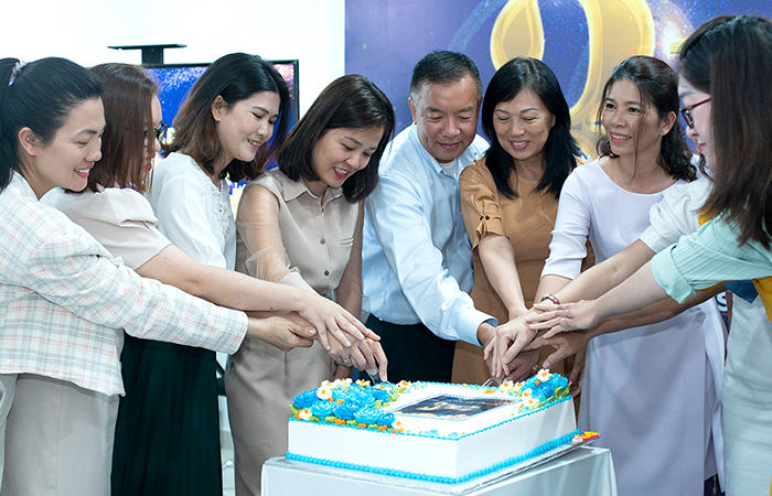 The Board of Directors slice a cake together to celebrate Fgroup's anniversary